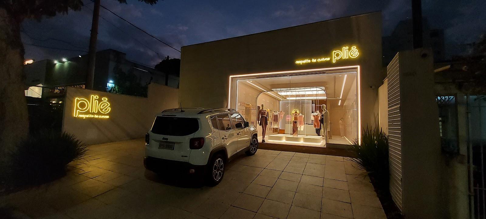 Fachada de loja à noite com letreiro de neon aceso