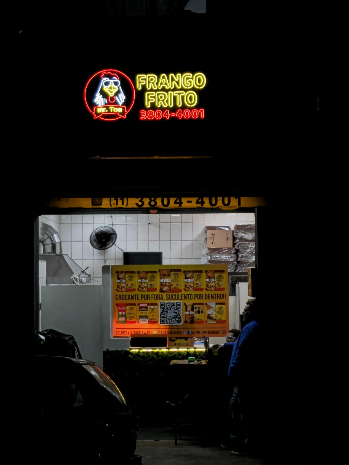 Letreiro iluminado sobre balcão de loja à noite