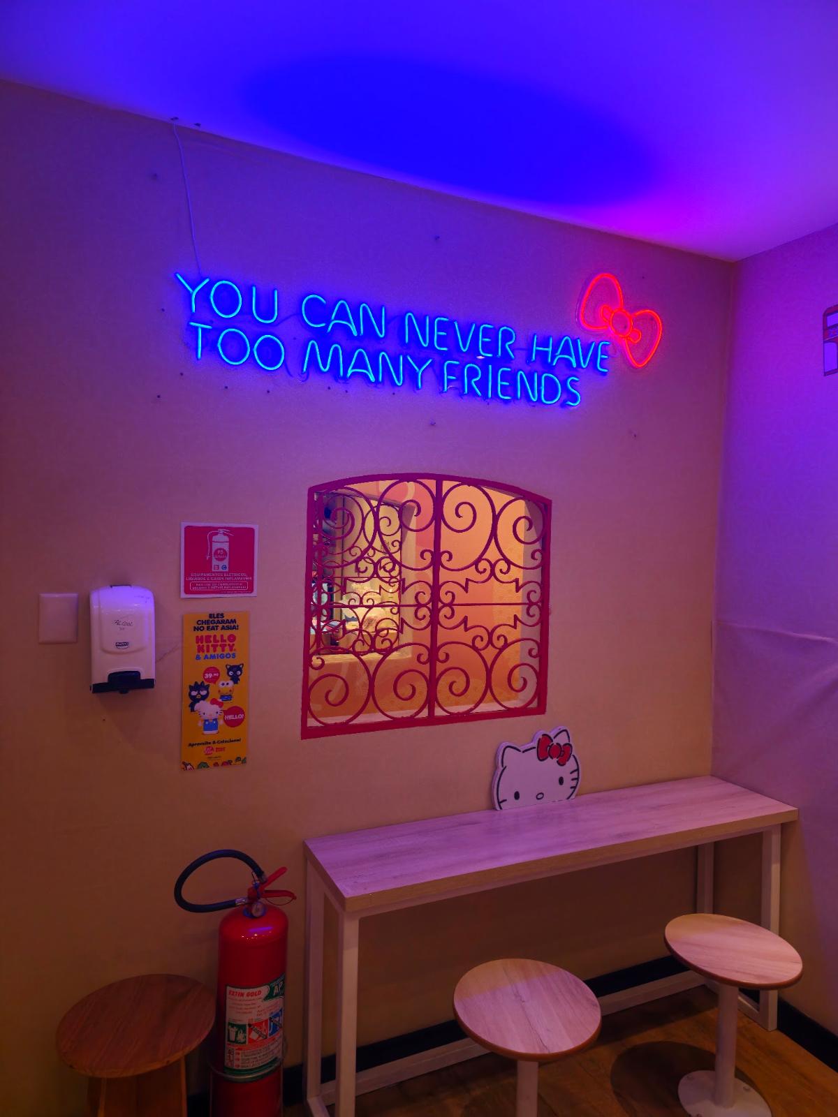 Corredor com neon azul e rosa e quadros na parede