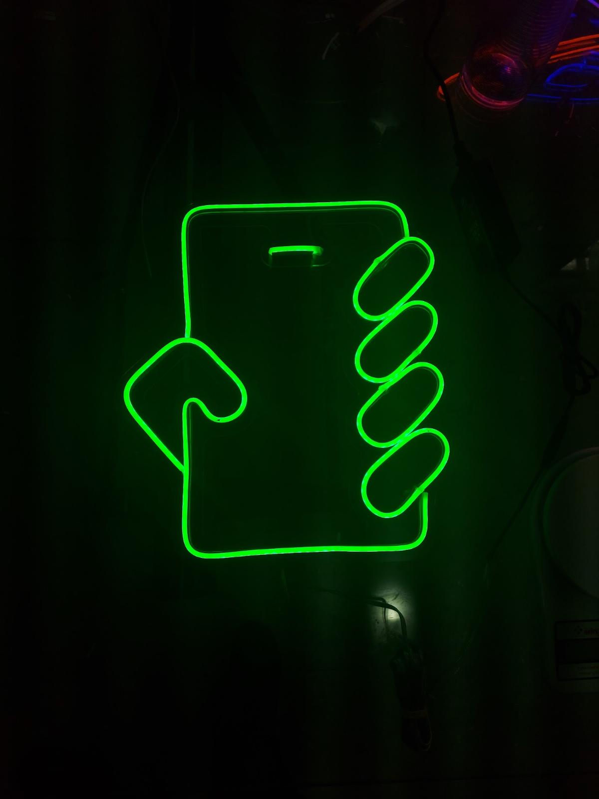 Neon verde em forma de celular em parede escura