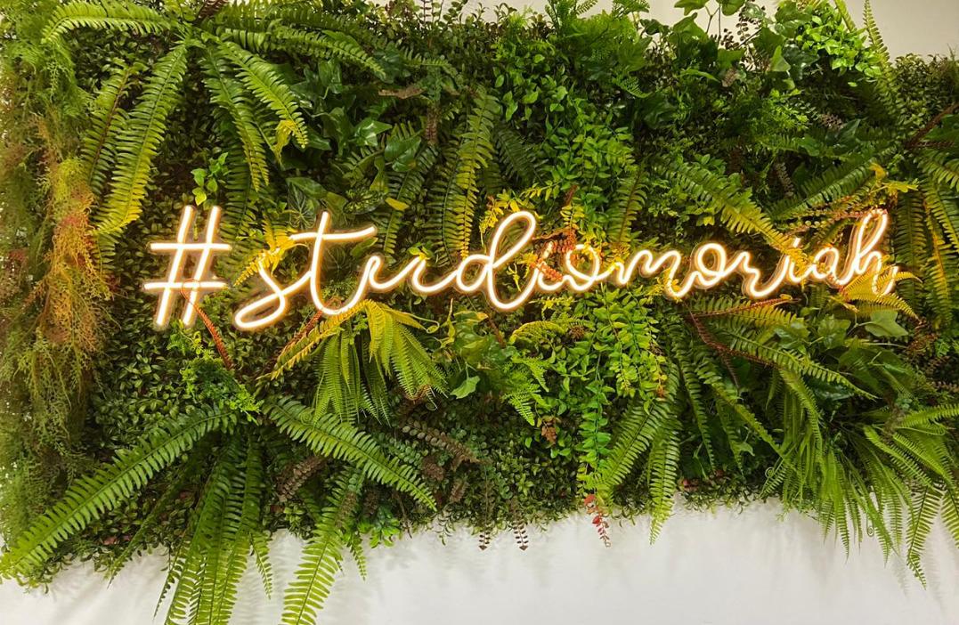 Neon dourado com hashtag em jardim vertical de salão