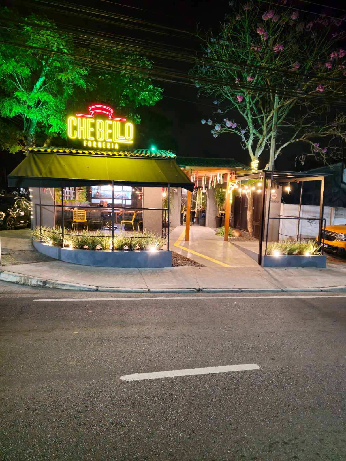 Quiosque de restaurante à noite com letreiro no telhado