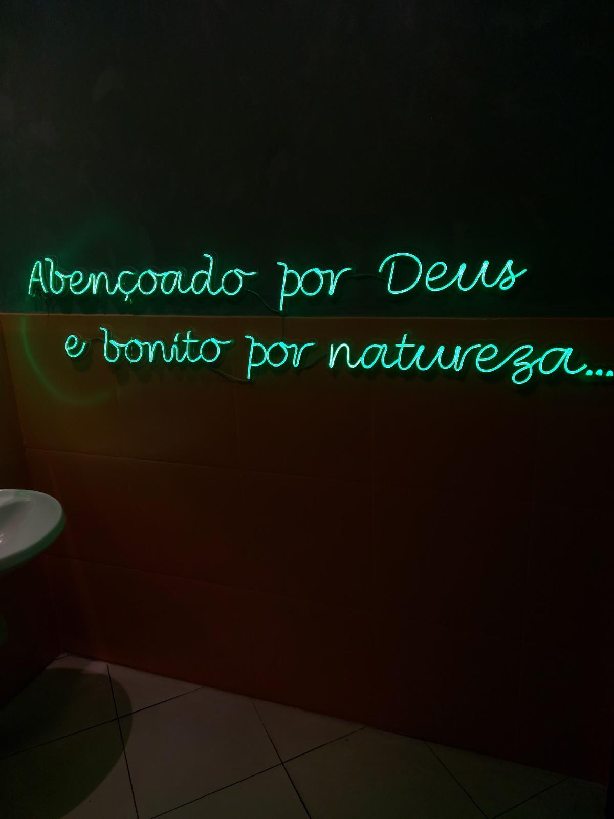 Neon verde com frase em parede de restaurante