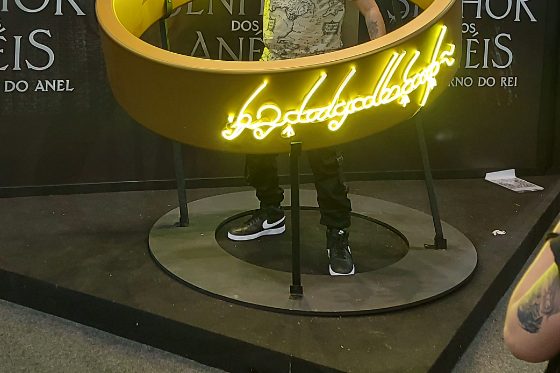 Cenografia de evento com lettering em neon LED âmbar em estrutura circular