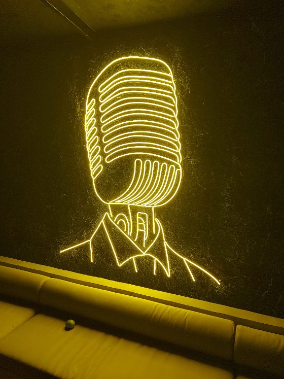 Ilustração de microfone em neon LED âmbar em lounge