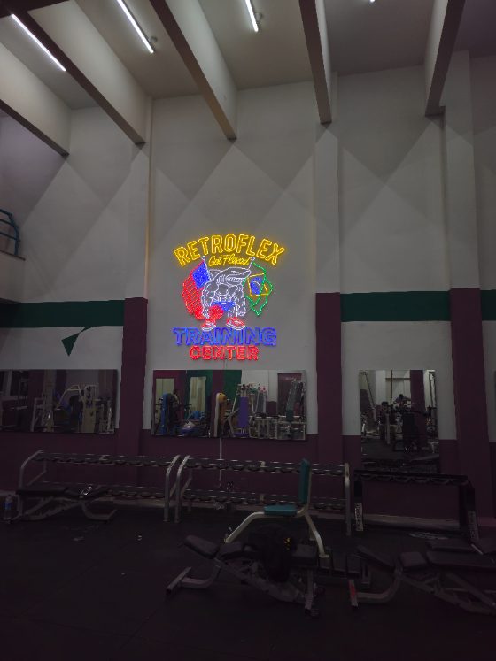 Logo em neon personalizado de academia, colorido, em parede alta