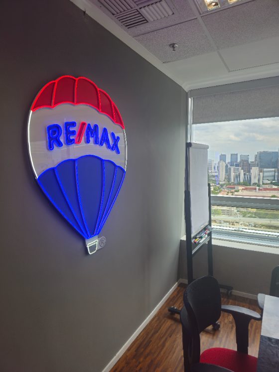 Logo em neon personalizado de empresa instalado em sala de reunião