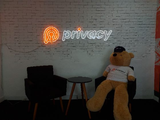 Logo em neon personalizado branco e laranja em parede de tijolo pintada